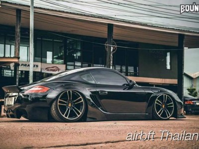 Black Porsche Cayman 987 cambergang speeding at low altitude