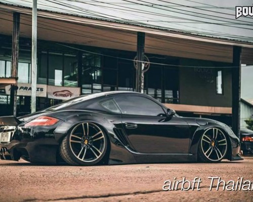 Black Porsche Cayman 987 cambergang speeding at low altitude